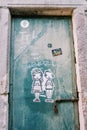 Graffiti of a boy and a girl with hearts on an old steel door