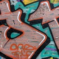 Graffiti on a concrete wall with bold, angular shapes in orange, black, and white Royalty Free Stock Photo