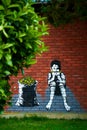 Graffiti drawing on a brick wall. A boy eats corn while sitting near a sack full of corn Royalty Free Stock Photo