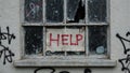 Graffiti Help sign on abandoned building window Royalty Free Stock Photo