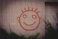 Graffiti painting of red happy smiley face on a concrete wall Royalty Free Stock Photo