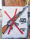Graffiti representing AAK47 rifle with a red cross on it