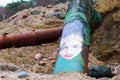 Graffiti on a rusty pipe, girl`s face painted on the pipe