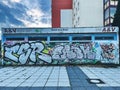 Graffiti on the wall of a vacant shop in Rostock under a blue cloudy sky Royalty Free Stock Photo