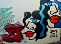 Graffiti with women's faces and lips in abstract style saying "Stay in love" in Lissabon, Portugal