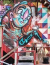 Grafitti of colorful figure drinking coffee in Auckland.