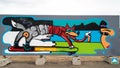 Grafitti in Sisimiut, Greenland, fox with city name on body on skateboard sprayin glandscape with ice and sea and face of girl.