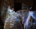 GRAGNOLA, LUNIGIANA, ITALY - AUGUST 10, 2019: Stilt walker ladies dance in their illuminated costumes in local evening