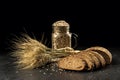 Grain bouquet, golden oats spikelets in jar on dark wooden table, buns and can filled with dried grains