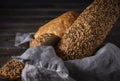 Grain bread in a basket with a napkin on a dark background, wheat loaf , close-up