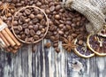 Grain coffee in a wooden cup and burlap. Cinnamon sticks are tied with string. Anise and dried slices of lemon on an old wooden bo