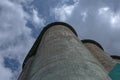 Grain elevator against a stormy sky. Large factory structure against a blue sky, low angle view Royalty Free Stock Photo