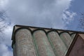 Grain elevator against a stormy sky. Large factory structure against a blue sky, low angle view Royalty Free Stock Photo