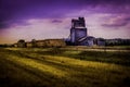 Grain elevator in countryside with hay bails