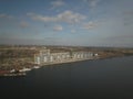 Grain elevator in the port on the river bank. Huge stainless steel tanks for storing crops. Aerial drone or quadrocopter aerial Royalty Free Stock Photo