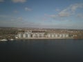 Grain elevator in the port on the river bank. Huge stainless steel tanks for storing crops. Aerial drone or quadrocopter aerial vi Royalty Free Stock Photo