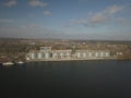 Grain elevator in the port on the river bank. Huge stainless steel tanks for storing crops. Aerial drone or quadrocopter Royalty Free Stock Photo