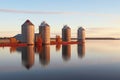 grain elevator silos reflecting in calm lake