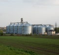 Grain elevators with green spring field in foreground Royalty Free Stock Photo