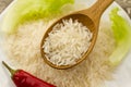 Grain rice in a wooden spoon on a background plate, green salad, chili pepper. Healthy eating, diet, vegetarianism. Royalty Free Stock Photo