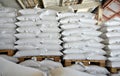 The grain sacks in the warehouse are stacked in straight rows.