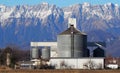 Grain storage bin with silos and distribution system at the foot of the mountains Royalty Free Stock Photo
