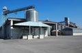Grain storage bins with silos and distribution system. The asphalt square in front of it is empty Royalty Free Stock Photo