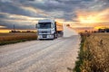 Grain truck on a rural road next to a rye field at sunset Royalty Free Stock Photo