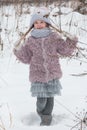 Graininess of the film the main object is out of focus a Little girl throws snow in the forest. Royalty Free Stock Photo