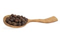 Grains of allspice on wooden spoon isolated on white background Royalty Free Stock Photo