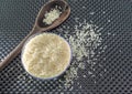 Grains of cereal rice on a dark background in a jar next to wooden spoon