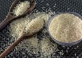 Grains of cereal rice on a dark background in a jar next to wooden spoon