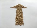 Grains of pearl barley laid out in the form of an arrow. Abstract composition.