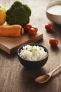 Grains of rice in a wooden bowl and ingredients for a vegetarian Royalty Free Stock Photo