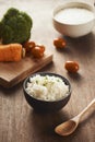 Grains of rice in a wooden bowl and ingredients for a vegetarian recipe - healthy eating concept Royalty Free Stock Photo