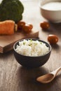 Grains of rice in a wooden bowl and ingredients for a vegetarian recipe - healthy eating concept Royalty Free Stock Photo