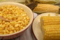 Grains of sweet corn in a plate and ears of corn on the wood table. Healthy diet. Fitness diet. For a sweet treat. Close up Royalty Free Stock Photo