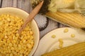 Grains of sweet corn in a plate with a wooden spoon, coarse salt and ears of corn on the table. Healthy diet. Fitness diet. For a Royalty Free Stock Photo