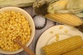 Grains of sweet corn in a plate with a wooden spoon, coarse salt and ears of corn on the table. Healthy diet. Fitness diet. For a Royalty Free Stock Photo