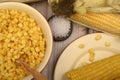 Grains of sweet corn in a plate with a wooden spoon, coarse salt and ears of corn on the table. Healthy diet. Fitness diet. For a Royalty Free Stock Photo