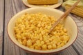 Grains of sweet corn in a plate with a wooden spoon and ears of corn on the table. Healthy diet. Fitness diet. For a sweet treat. Royalty Free Stock Photo