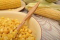 Grains of sweet corn in a plate with a wooden spoon and ears of corn on the table. Healthy diet. Fitness diet. For a sweet treat. Royalty Free Stock Photo