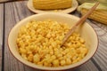 Grains of sweet corn in a plate with a wooden spoon and ears of corn on the table. Healthy diet. Fitness diet. For a sweet treat. Royalty Free Stock Photo