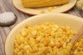 Grains of sweet corn in a plate with a wooden spoon and ears of corn on the table. Healthy diet. Fitness diet. For a sweet treat. Royalty Free Stock Photo