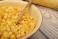 Grains of sweet corn in a plate with a wooden spoon and ears of corn on the table. Healthy diet. Fitness diet. For a sweet treat. Royalty Free Stock Photo