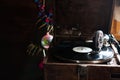 Gramophone playing a record. with vinyl on background decorations, cap, tree and bright lights Royalty Free Stock Photo