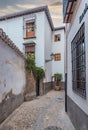 Granada empty narrow streets around Carrera Del Darro. Narrow cobbled streets of Granada in sunshine and blue sky above.