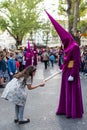 Granada spain, 14 April 2014. Holy week procession. Girl making a ball of wax with the candle of a Nazarene.