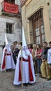 Granada Spain, April 17, 2014: Penitents dressed in white and red holding large candles from the Aurora de Granada procession