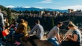 Tourists admiring the view of Alhambra and the city of Granada in Andalusia, Spain with snowy Sierra Nevada in the background Royalty Free Stock Photo